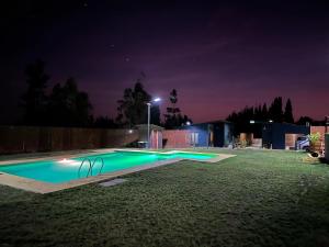 a swimming pool in a yard at night at Ecoraleo in Concepción