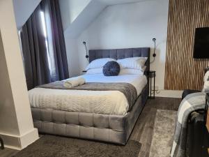 a bedroom with a large bed with a gray headboard at Quantock Loft Studio 3 in Rochester