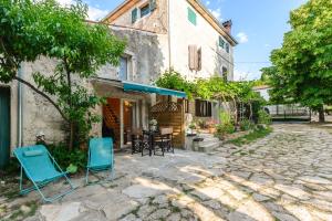 een huis met twee blauwe stoelen in een tuin bij Stella Marina Deluxe Apartment in Poreč