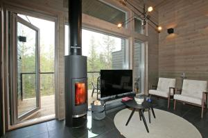 een woonkamer met een open haard en een televisie bij Villa Kanger Ruka1 in Kuusamo