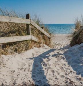 un chemin menant à la plage avec des empreintes de pieds dans le sable dans l'établissement KvarteretSkatan!, à Ystad