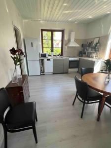 a living room with a table and chairs and a kitchen at KvarteretSkatan! in Ystad