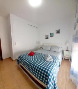 sypialnia z łóżkiem z niebiesko-białym kocem szachowym w obiekcie Appartamento Mochiri - San Isidro w mieście San Isidro