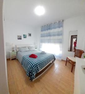 1 dormitorio con cama, mesa y ventana en Appartamento Mochiri - San Isidro, en San Isidro