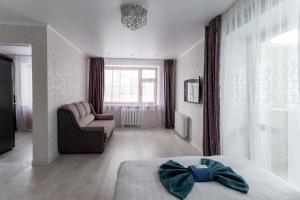1 dormitorio con 1 cama, 1 sofá y 1 silla en Альпина en Petropavlovsk