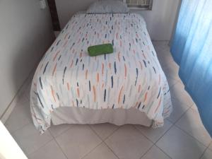 un letto con piumone bianco e oggetto verde sopra di Las Palmas Day & Night Guest House a Pretoria