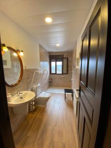 a bathroom with a sink and a toilet and a tub at El Mirador del Chorrillo in Olmeda de las Fuentes