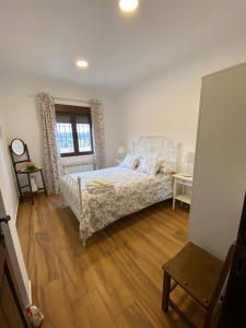 1 dormitorio con 1 cama y suelo de madera en El Mirador del Chorrillo, en Olmeda de las Fuentes