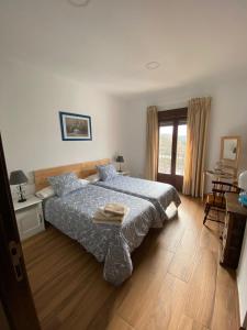 a bedroom with a bed with a blue comforter at El Mirador del Chorrillo in Olmeda de las Fuentes