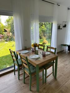 a dining room table with chairs and a large window at Casa de pe un Deal-Provita de Sus-Prahova in Proviţa de Sus