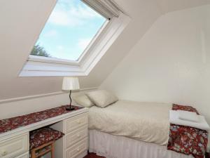 a attic bedroom with a bed and a window at Dunard Villa in Stornoway