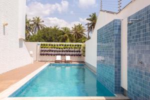 a swimming pool in a house with blue tiles at Hotel de Luxo Tango Suites & Coworking Cumbuco in Cumbuco
