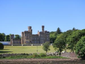 an old castle with trees in the foreground at Dunard Villa in Stornoway