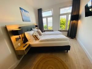 a bedroom with a large bed and a window at Strandhaus Blankenese in Hamburg