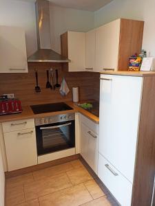 a kitchen with a stove and a white refrigerator at Bed and Bike Rheine in Rheine