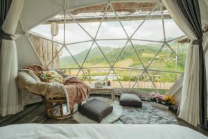 a room with a large glass window with a chair in front at Paopao Orange Farm and Home stay in Mae Rim