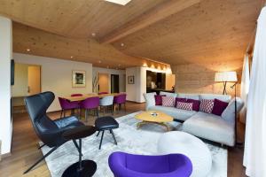 ein Wohnzimmer mit einem Sofa, Stühlen und einem Tisch in der Unterkunft Hotel Krone Lenk in Lenk im Simmental