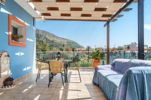 a patio with a table and chairs and a view of a mountain at Efrosyni apartment in Markópoulon