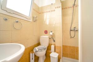a bathroom with a toilet and a sink and a shower at Spyros apartment in Markópoulon