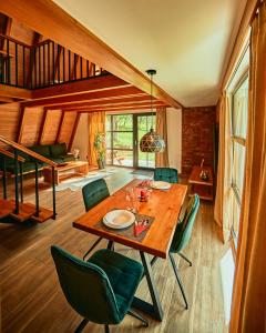une salle à manger avec une table en bois et des chaises vertes dans l'établissement Aruna Bran, à Bran