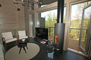 a living room with a fireplace and a television at Villa Kanger Ruka 2 in Kuusamo