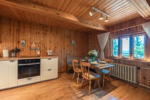uma cozinha com paredes de madeira e uma mesa com cadeiras em Dom na Szczycie Góry Równica em Ustroń