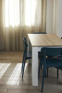 a dining room table with two blue chairs and a window at Appartamento Felicia in Castel di Sangro