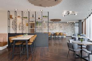 a restaurant with tables and chairs in a room at Courtyard by Marriott Linz in Linz