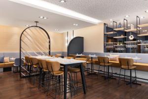 a restaurant with tables and chairs and a bar at Courtyard by Marriott Linz in Linz