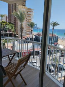 d'un balcon avec une table et une vue sur la plage. dans l'établissement Apartamento La Concha PLAYA DE LEVANTE, à Benidorm