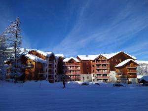 een persoon die in de sneeuw voor een lodge staat bij Appartement Vars in Vars