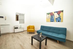 Appartamento Felicia في كاستل دي سانجرو: غرفة معيشة مع أريكة زرقاء وطاولة