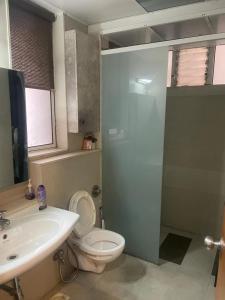 uma casa de banho com um WC, um lavatório e um chuveiro em Royal Nest (AS) 3 BHK Suite em Pune