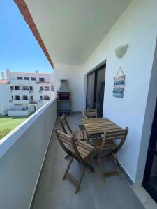 a patio with a table and chairs on a balcony at Elm Apartament in Sagres