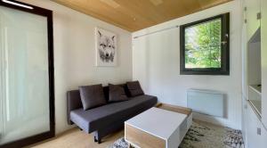 a living room with a couch and a window at Studio rénové avec terrasse Sud idéalement situé in Combloux