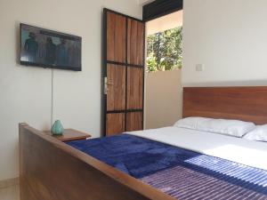 a bedroom with a bed and a tv on the wall at Rosa negra kampala in Kigo