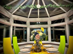 una mesa de comedor con un jarrón de flores. en 6 Bedroom House-Sleeps 12-Big Savings On Long Stays!, en Colchester