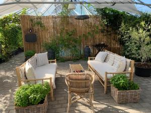 a patio with three chairs and a table and a fence at Mariegaardens Gæstehuse in Hillerød