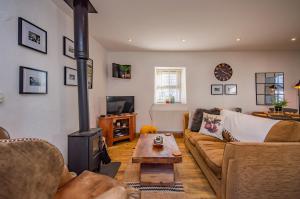 a living room with a couch and a wood stove at Cosy Farm Conversion In The Heart Of Pembrokeshire in Pembrokeshire