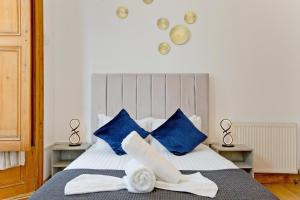 a bedroom with a bed with blue and white pillows at Imperial Earls Court Apartments in London