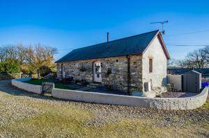 an old stone church with a black roof at Cosy Farm Conversion In The Heart Of Pembrokeshire in Pembrokeshire