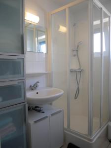 La salle de bains blanche est pourvue d'un lavabo et d'une douche. dans l'établissement Nova Park V43, au Coq