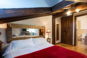 1 dormitorio con 1 cama grande con manta roja en Casa Rural Adolfo, en Santa Inés