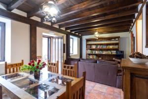 a dining room with a glass table and a library at Casa Rural Adolfo in Santa Inés