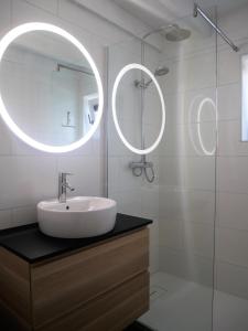 een witte badkamer met een wastafel en een spiegel bij Nova Park V88 in De Haan