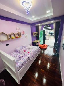 sypialnia z białym łóżkiem i fioletowymi ścianami w obiekcie KITJA MY HOME w mieście Hat Yai