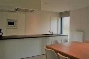 een keuken met een houten tafel en een aanrecht bij Strandhuis 0102 in De Haan