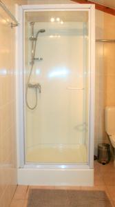 a shower with a glass door in a bathroom at Village Park P25 in De Haan