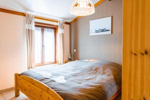 a large bed in a room with a window at Village Park P25 in De Haan