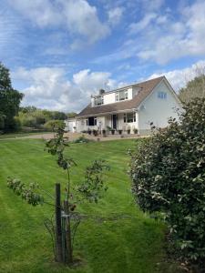 a large white house with a grass yard at Woodland House B & B in Wimborne Minster